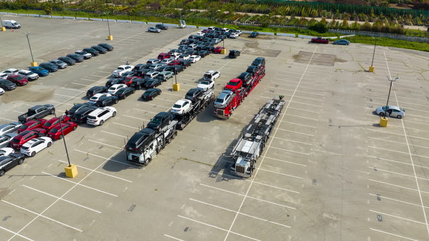 Aerial top down view of a car carrier trailer. car-carrying trailer loading the cars. Big rig long haul semi truck tractors transporting cars. Time lapse.  Royalty-Free Stock Footage #1110511187