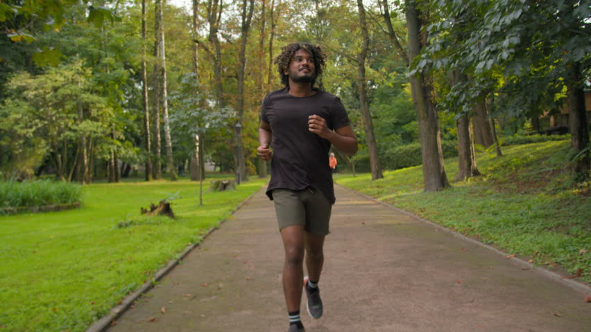 Happy sporty athlete Arabian Indian male runner morning run in city urban park running outdoors healthy active sport lifestyle fitness man sportsman jogging sports activity training jog cardio workout Royalty-Free Stock Footage #1110512179