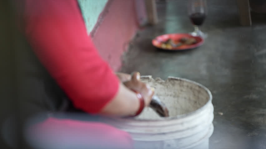A woman from Lake Begnas, 14 kms away from the city of Pokhara, Nepal uses her hands to prepare and clean a Tilapia fish for marination and grilling. 