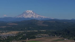 Drone footage flying over Puyallup, Washington with a view of the city of Orting and Mount Rainier in the background.