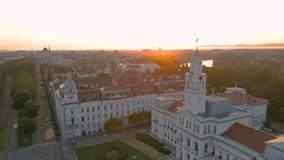 Aerial footage over Arad city center at sunrise, with the Administrative palace in the view. Video was shot from a drone, in the morning, while flying backwards with camera level.