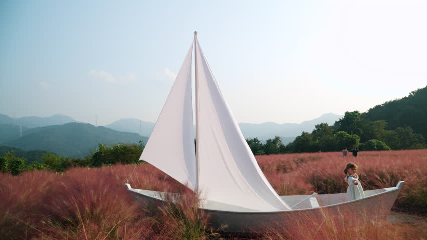 Little Girl Playing Sailor Inside Wooden Sail Boat at Pink Muhly Grass Field - Herb Island Farm in Pocheon