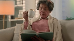 Calm serious Caucasian old woman covered with blanket on sofa drinking tea coffee with cup reading book senior mature lady elderly female retired pensioner grandmother read novel drink at home couch - Powered by Shutterstock - Get 15% off with code: PIKWIZARD15