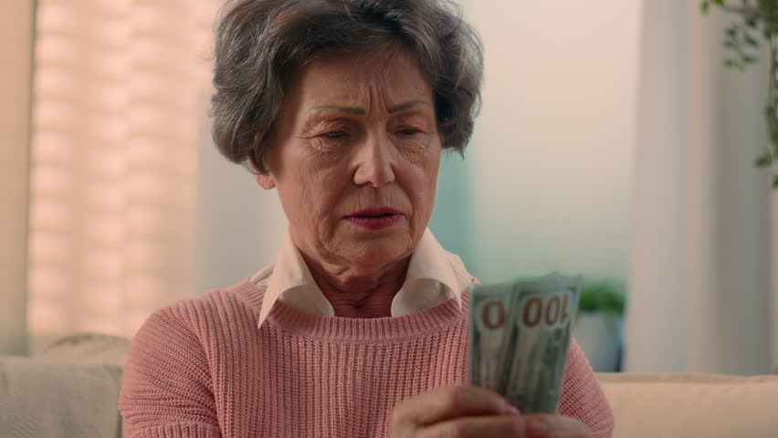 Sad dissatisfied stressed Caucasian old woman count money at home worry with debt world financial crisis bills grandmother counting fake dollars senior old female retired lady upset banknotes cash Royalty-Free Stock Footage #1110533187