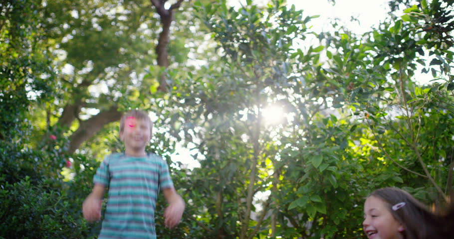 Trampoline, happy or kids jump in backyard for fun games on holiday vacation to relax together. Wellness, bounce or excited children in nature playing game or activity for freedom or energy in summer