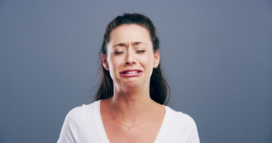 Sad, crying and young woman in a studio with upset, worry and depression face expression. Emotions, grief and female person from Canada with tears for broken heart isolated by gray background. | Shutterstock HD Video #1110537963