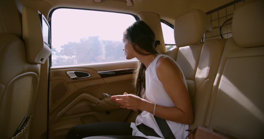 Business woman, phone and texting in car, reading and thinking for smilel, networking or contact. Happy entrepreneur, smartphone and social media in vehicle for travel, transport and drive in traffic