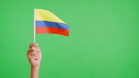 Wind waving a colombian pennant holding by a hand