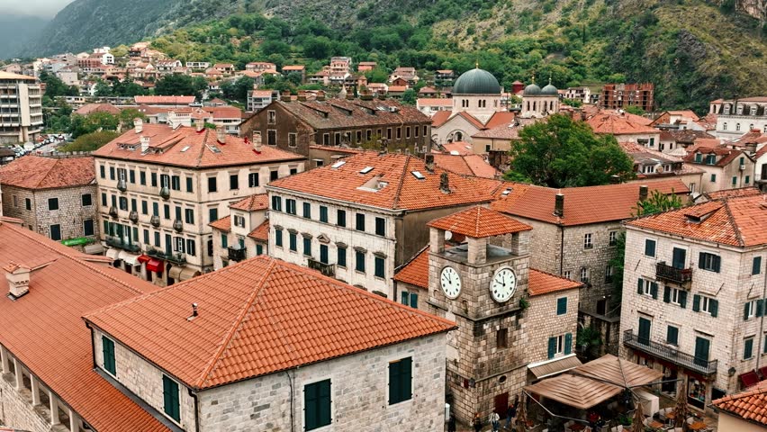 Old town Kotor Montenegro on the coast of Boka bay in the Mediterranean. Vacation destination and tourist trap in Europe. Aerial drone view of waterfront and stone houses. Royalty-Free Stock Footage #1110544619