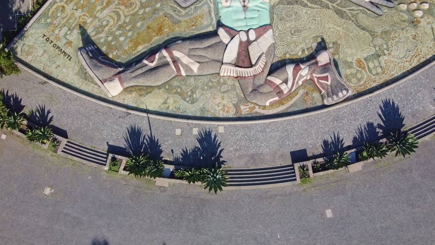 Aerial view of the majestic Tláloc Fountain, an iconic Mexican cultural symbol, within the lush greenery of Chapultepec Forest in Mexico City, captured by a drone