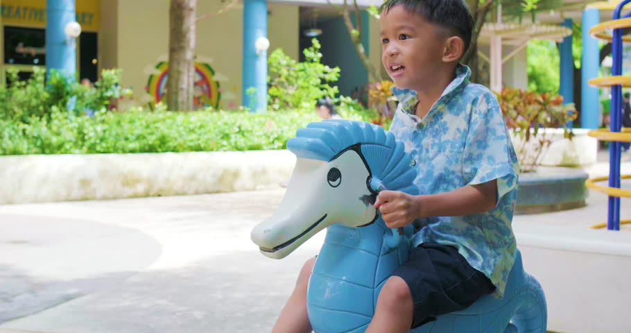 Happy asian lindergarten 5 year boy enjoying with outdoor city playground summer vacation