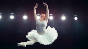 Happy Ballet Dancer Performs a Powerful Split Leap During Her Dance Act. Young Smiling Female Practicing in Striking Beautiful Dress on a Dark Stage. Cinematic Super Slow Motion Speed Ramp Footage - Powered by Shutterstock - Get 15% off with code: PIKWIZARD15