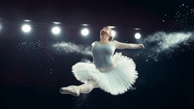 Portrait of a Talented Ballet Dancer Performing on Stage. Young Female Making a Split Leap Jump and Releasing Powder From Her Hands in a Dark Studio. Cinematic Super Slow Motion Speed Ramp Footage - Powered by Shutterstock - Get 15% off with code: PIKWIZARD15