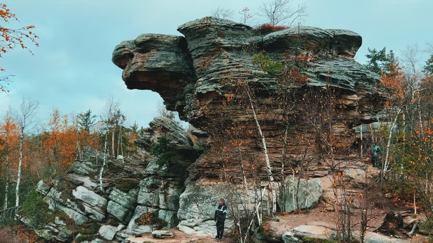 Stone City in autumn. Bright foliage and autumn landscape. The natural landscape is a rock formation in Central Russia, the Urals. A natural monument. Ancient rocky folding in the Ural Mountains. 4K