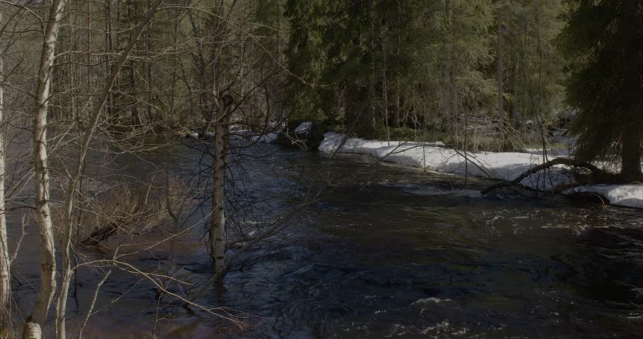 Flowing river at Lounatkoski rapids with old wooden bridge in spring, Hossa, Suomussalmi, Finland.
