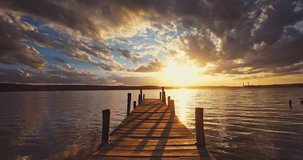 Small Wooden Dock and Boat at the lake during sunset with dramatic cloudscape 4k timelapse video