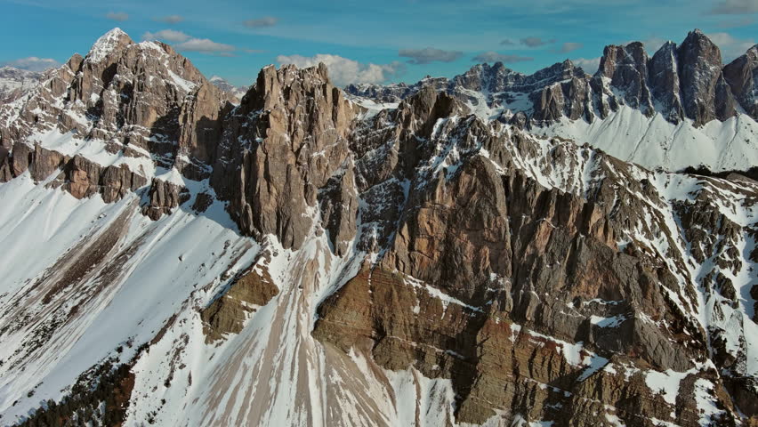 Aerial view of amazing rocky mountains in snow at sunset, Dolomites, Italy, 4k