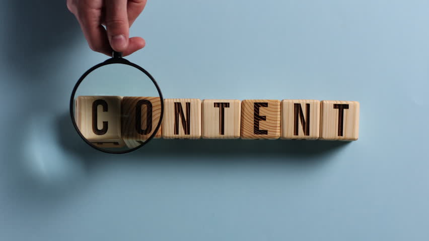 Wooden cubes with the word CONTENT on a blue table. Cubes with black letters.