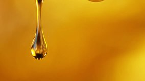 Super Slow Motion Shot of Falling Golden Oil Droplets Isolated on Orange Background at 1000 fps. - Powered by Shutterstock - Get 15% off with code: PIKWIZARD15