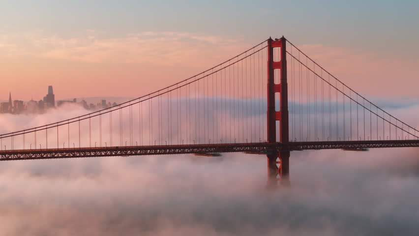 Epic landscape with cinematic pink clouds floating around scenic red Golden Gate bridge with San Francisco cityscape on motion background. Breathtaking views on major USA landscape. Tourism background