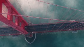 Breathtaking aerial of cinematic Golden Gate at sunset. Cars driving by red bridge covered in scenic clouds. Karl the Fog drifting below red bridge main landmark of San Francisco California USA 4K