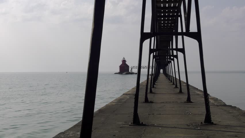 Sturgeon Bay lighthouse on Lake Michigan. Wide shot, through the catwalk uprights, that pushes in towards the lighthouse itself. Shot on a very overcast day as Canadian wildfire smoke moves in.