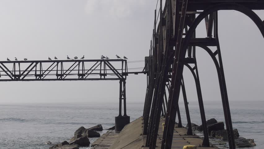 Sturgeon Bay lighthouse on Lake Michigan. Closeup shot of the lighthouse that starts at the catwalk and pans left across the catwalk with gulls. Very overcast day as Canadian wildfire smoke moves in.