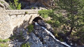 An ancient stone arch bridge. This video from Corsica perfectly encapsulates the harmony between human-made structures and the raw power of nature. 