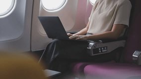 In-Flight Productivity, Woman Effectively Uses a Laptop While Seated by an Airplane Window - Powered by Shutterstock - Get 15% off with code: PIKWIZARD15