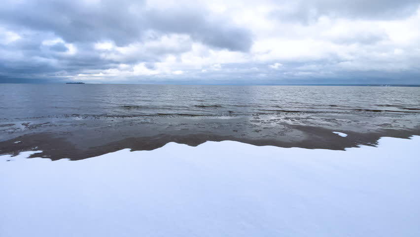  Winter seascape. Winter. The sea shore covered with snow. Sea waves. Horizon. Natural background. North. Ocean. The north pole. Beach.