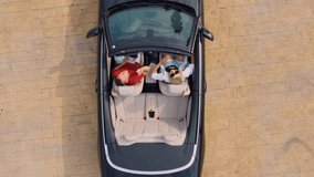 Man and woman in black convertible on coast, sea on prominat with palm trees. . Best friends spend summer together. People are happy and enjoy life. Road by car to sea. Friendship and love forever. - Powered by Shutterstock - Get 15% off with code: PIKWIZARD15