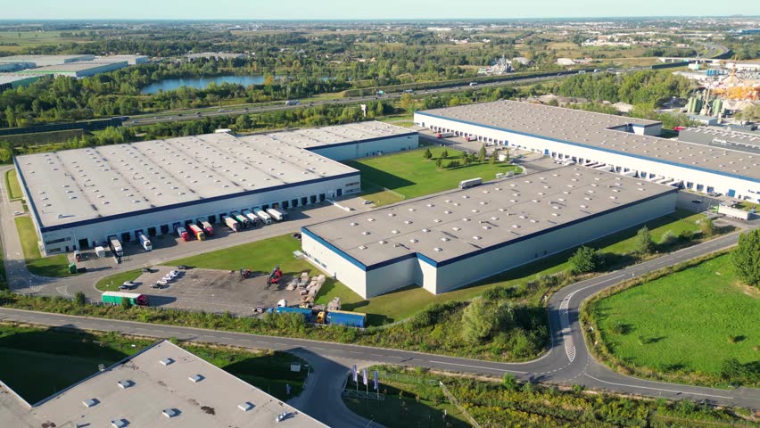 Aerial view of goods warehouse. Logistics center in industrial city zone from above. Aerial view of trucks loading at logistic center stock photo