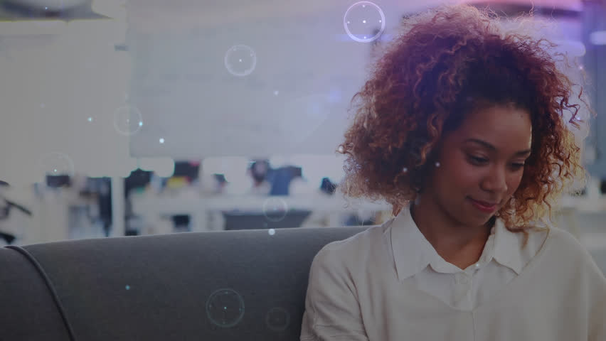 Animation of network of connections against african american woman using smartphone at office. Global networking and business technology concept