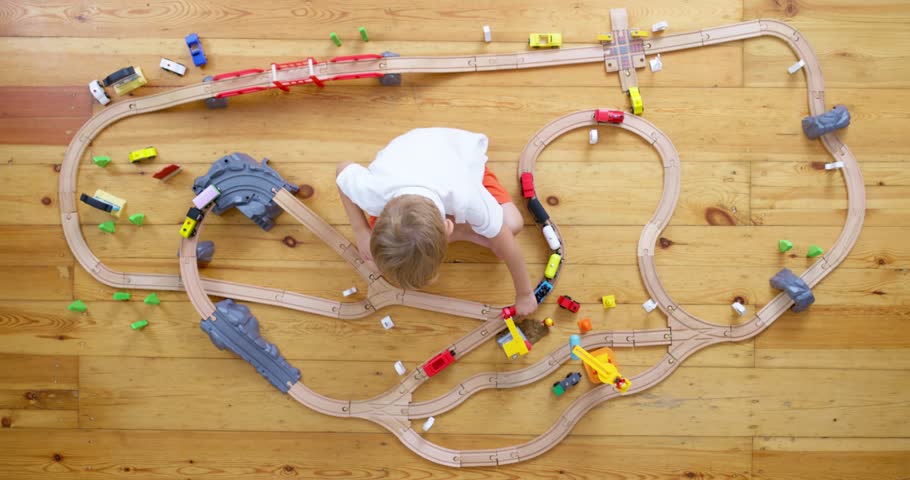 Cute child playing with toy wooden railroad on the floor at home or kindergarten Royalty-Free Stock Footage #1110629659