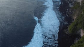 Aerial 4K Drone Footage: Majestic Sunset at Uluwatu Temple, Bali; Ocean Waves Crashing Against Towering Cliffs, Enchanting Golden Hour Orbiting Shot; Perfect for Serenity Videos and Travel Vlogs