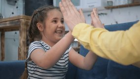 Happy family concept. Mom sits with her daughter on sofa in room and plays clapping. Mom and daughter are having fun in isolation. Family mother and child having fun on sofa at home. clap their hands - Powered by Shutterstock - Get 15% off with code: PIKWIZARD15