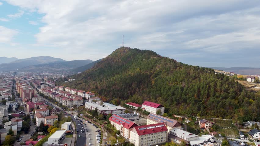 Aerial view from a drone flying to a mountain above the city