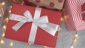 A woman takes a gift from under a Christmas tree and picks up a package. The atmosphere of the new year and surprises. Preparing for the exchange of gifts. Waiting for a surprise - Powered by Shutterstock - Get 15% off with code: PIKWIZARD15