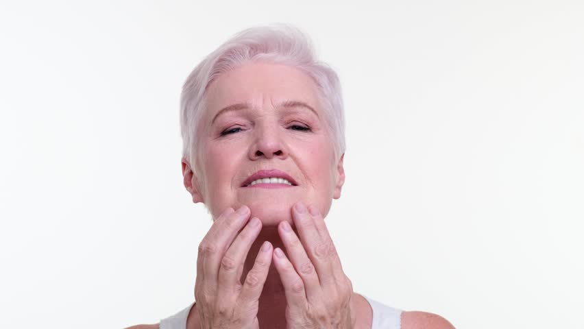 Old Woman Touching Her Face on White Background