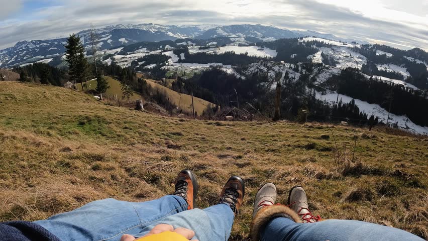 Legs view of senior couple resting and enjoy landscape at mountain peak during hiking day Royalty-Free Stock Footage #1110641273