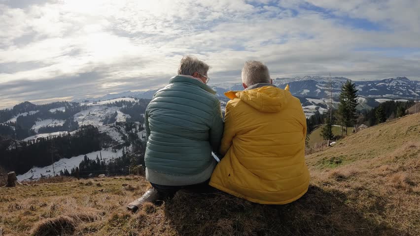 Back view of senior couple resting and enjoy landscape at mountain peak during hiking day Royalty-Free Stock Footage #1110641293