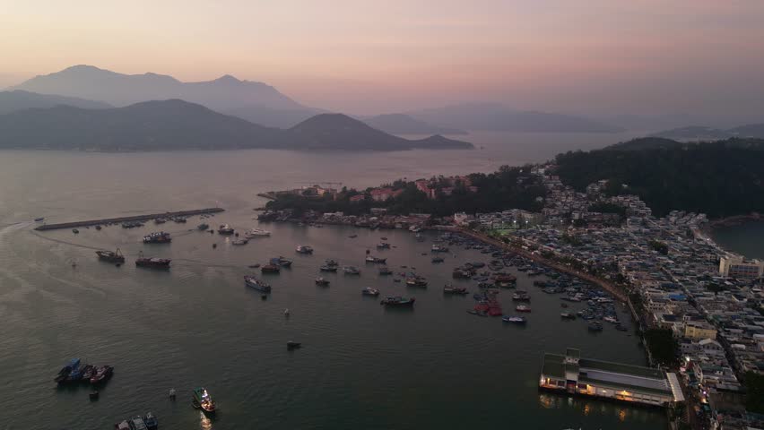 Cheung Chau, Hong Kong: Aerial drone footage of a dramatic sunset over the Cheung Chau island, famous for its fisherman harbor and relaxing traditional town in Hongkong. Shot with a rotation motion