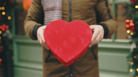 Valentine's Day. Male hands showing a red gift box for Valentine's Day to camera, birthday, or anniversary on the winter street. Love. Present Box. Close Up - Powered by Shutterstock - Get 15% off with code: PIKWIZARD15