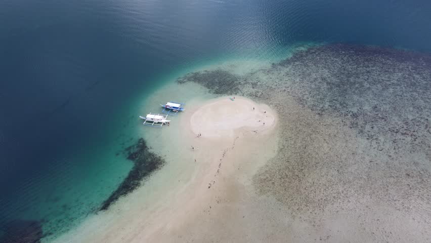 Starfish island in Port barton with island-hopping tour boats and people on vanishing sandbar. Aerial Royalty-Free Stock Footage #1110652309
