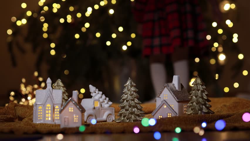 Child dances near a Christmas tree. Beautiful bokeh and light reflections.
