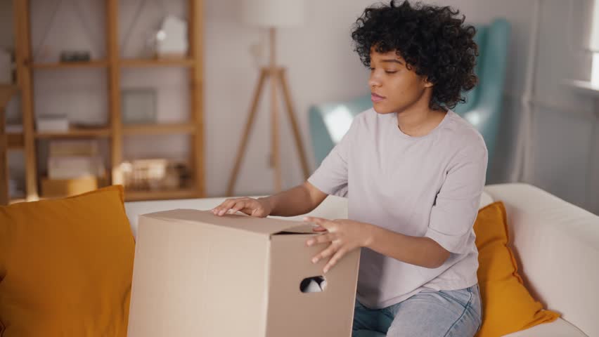Unhappy african american woman client feeling dissatisfied with received item in box telling complaints in mobile phone audio message. Stressed young female client having negative shopping experience. Royalty-Free Stock Footage #1110654413