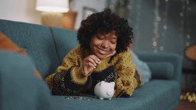 Saving money. Happy African American girl with banking goals finance safe. Woman imagines how she increase savings Piggy bank for savings, financial investment and profit Investment and income concept - Powered by Shutterstock - Get 15% off with code: PIKWIZARD15