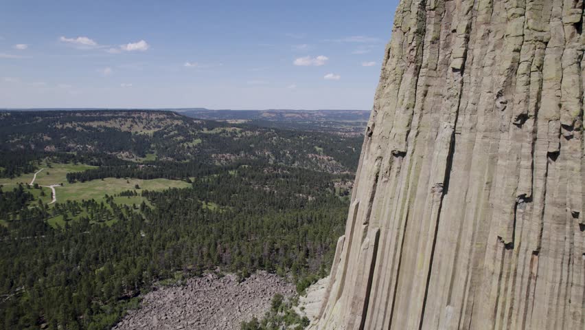 A drone shot of Devils Tower, a massive, monolithic, volcanic stout tower, or butte, located in the Black Hills region of Wyoming.