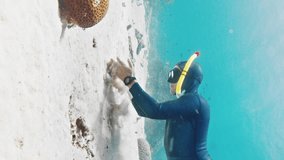 Extreme slow motion freediving with speed warp. Male freediver glides in the tropical sea over the sandy bottom and plays with sand. Speed warp edition of the footage