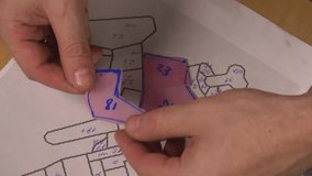 the decorative artist lays out pieces cut from paper with numbers and traces them on the glass so that the parts match in size when creating a stained glass window - Powered by Shutterstock - Get 15% off with code: PIKWIZARD15